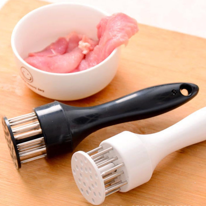 Two meat tenderizers on a wooden surface with a bowl of raw meat in the background.