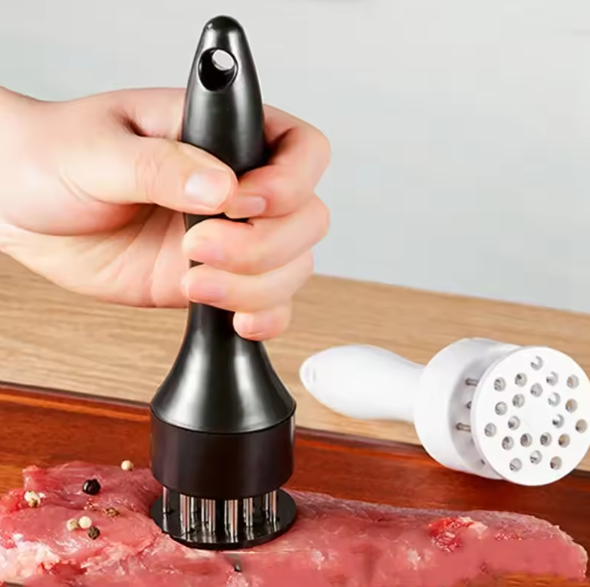 Hand using a meat tenderizer on raw meat with a white background